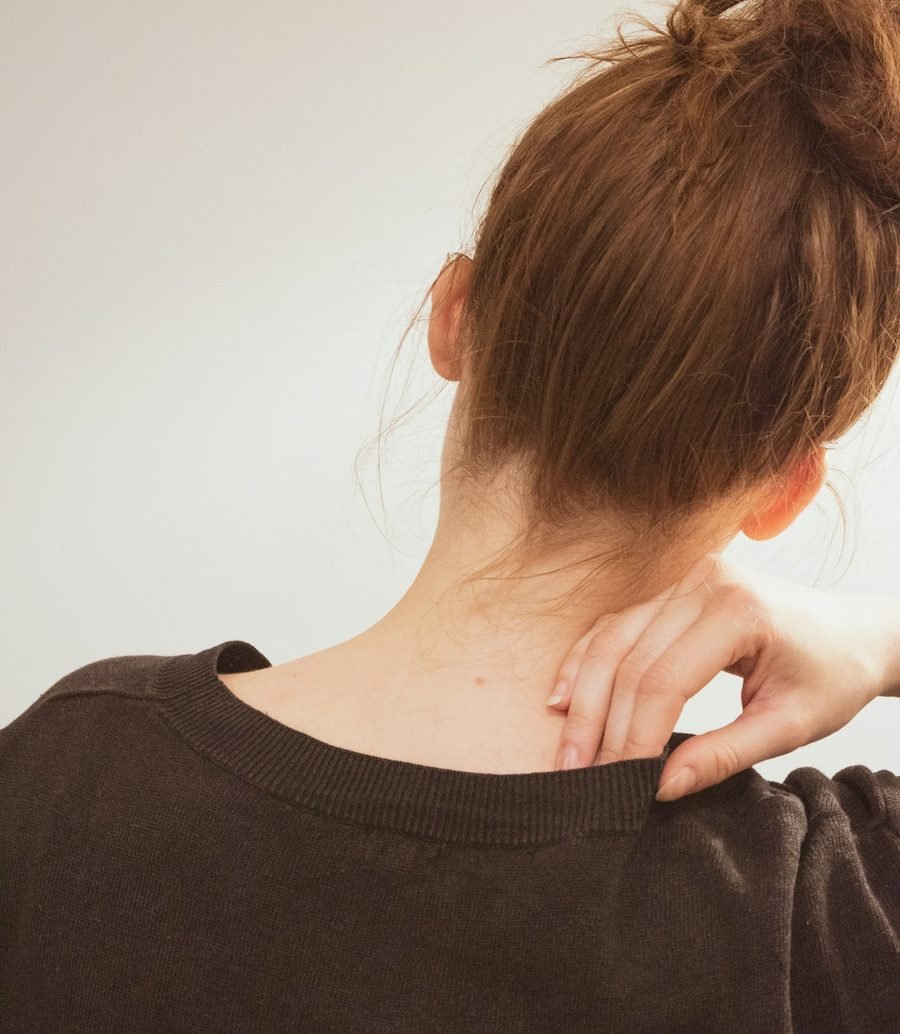 Woman holding her shoulder where neck and shoulder tension builds